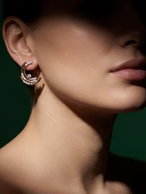 Twisted hoop earrings on a model in shadowed profile