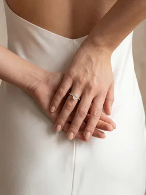 White-metal ring on hands against a white gown