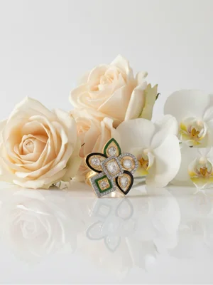 Green enamel ring among white roses and orchids
