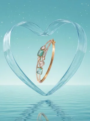 Emerald bangle inside a glass heart over water