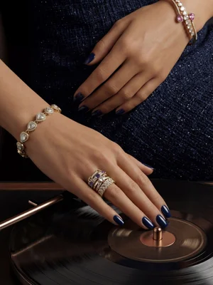 Bracelet and ring on a hand resting on a record player