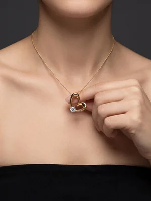 Gold heart pendant at the collarbone