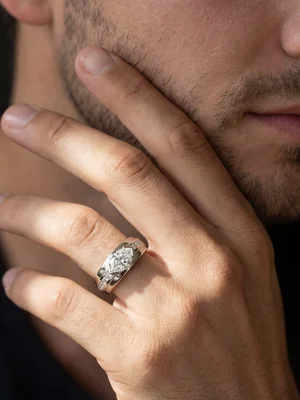White-metal ring on a man's hand at his jaw