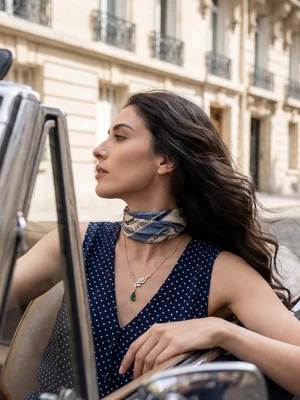 Green-stone pendant on a model in an open-top car