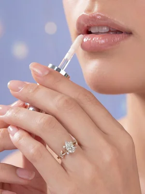 White-metal ring on a hand raised to the lips