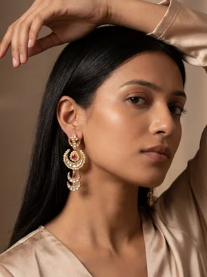Model in a warm studio portrait wearing large drop earrings