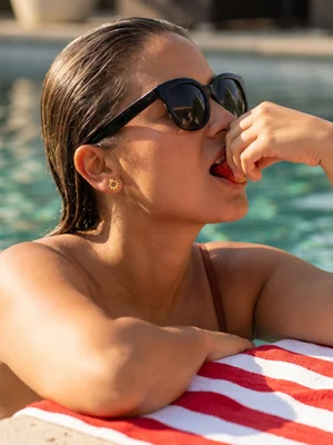 Small stud on a model in sunglasses at a pool