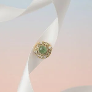 Green gemstone stud on a blush ribbon