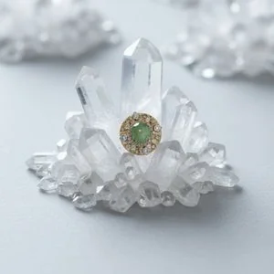 Green gemstone stud resting on raw quartz crystal