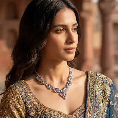 The same blue-stone necklace on a model in an embroidered blouse, shot with AI by Kaptured.AI