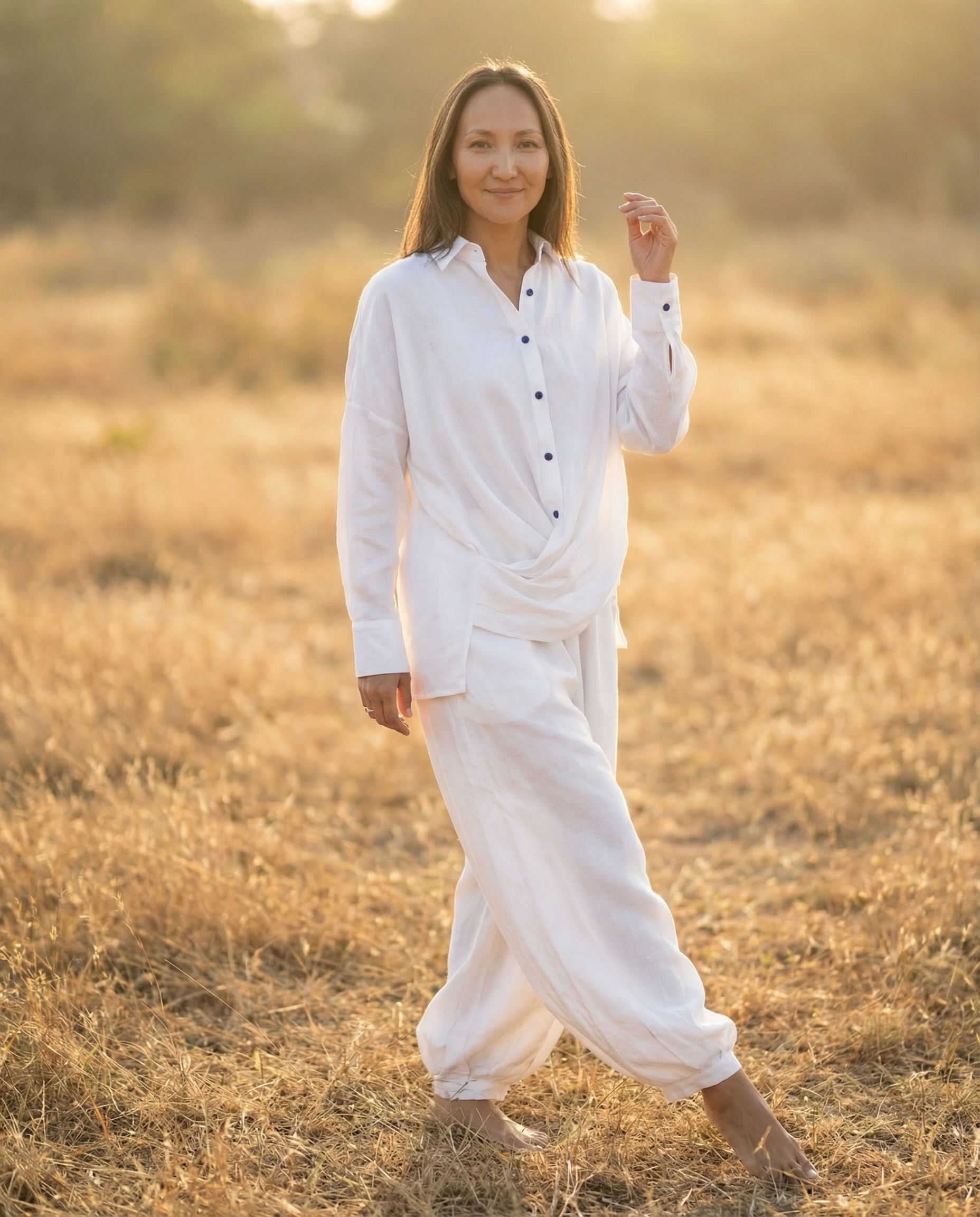 The K Way model walking through a golden field at sunset in a white co-ord set