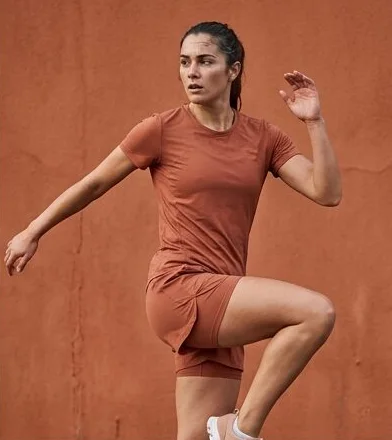 Activewear look on a model moving past a terracotta wall, an AI photoshoot by Kaptured.AI
