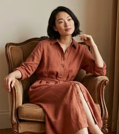 Sustainable fashion look on a model seated in a leather armchair indoors, an AI photoshoot by Kaptured.AI