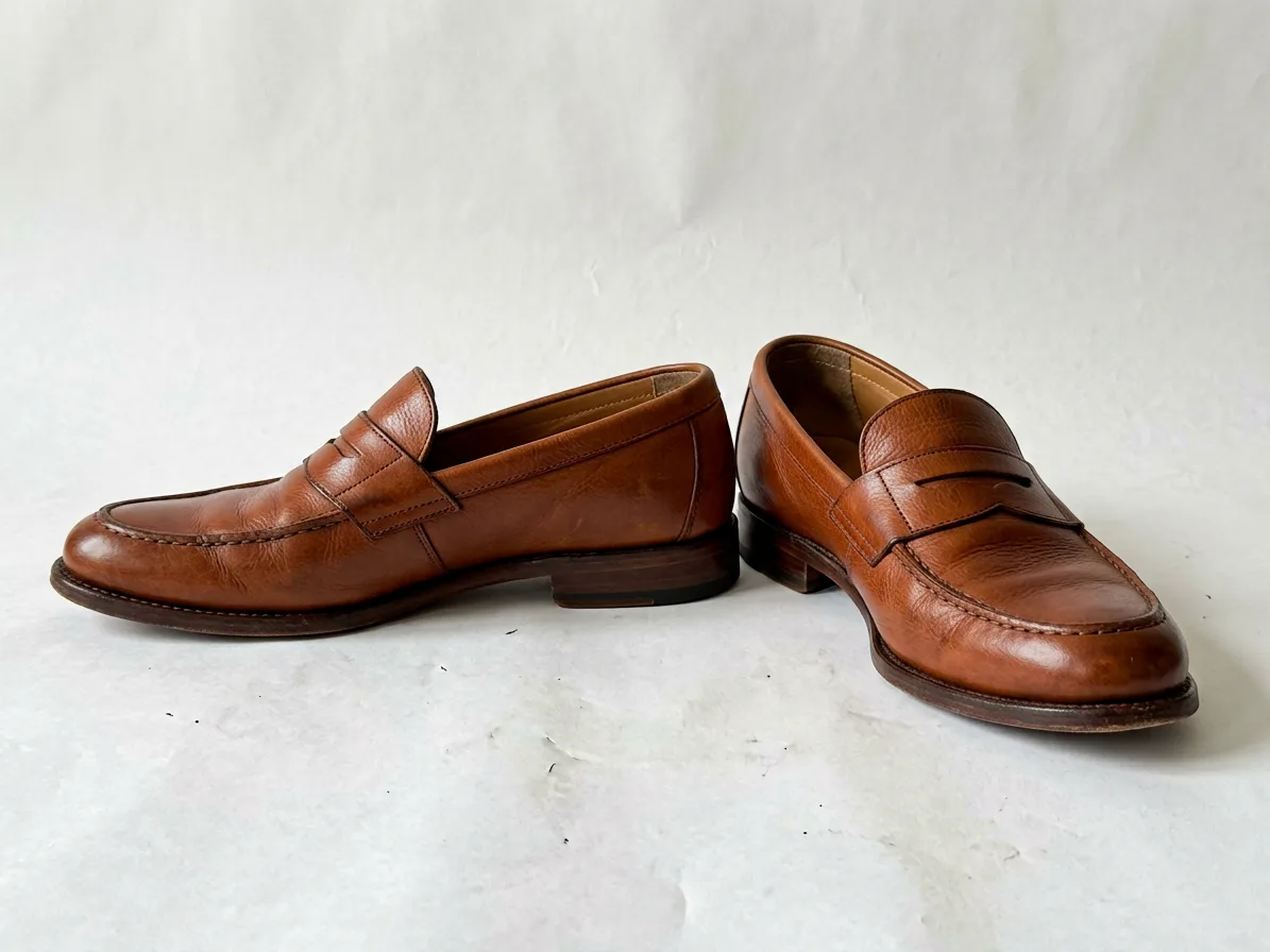 Pair of cognac leather loafers on a pure white background, made with AI