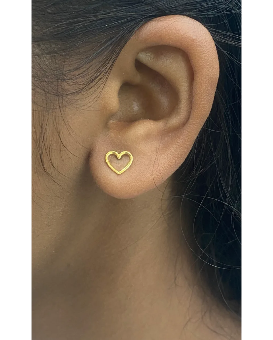 Phone photo of a gold heart stud on the ear, as Ghare Jewellers sent it